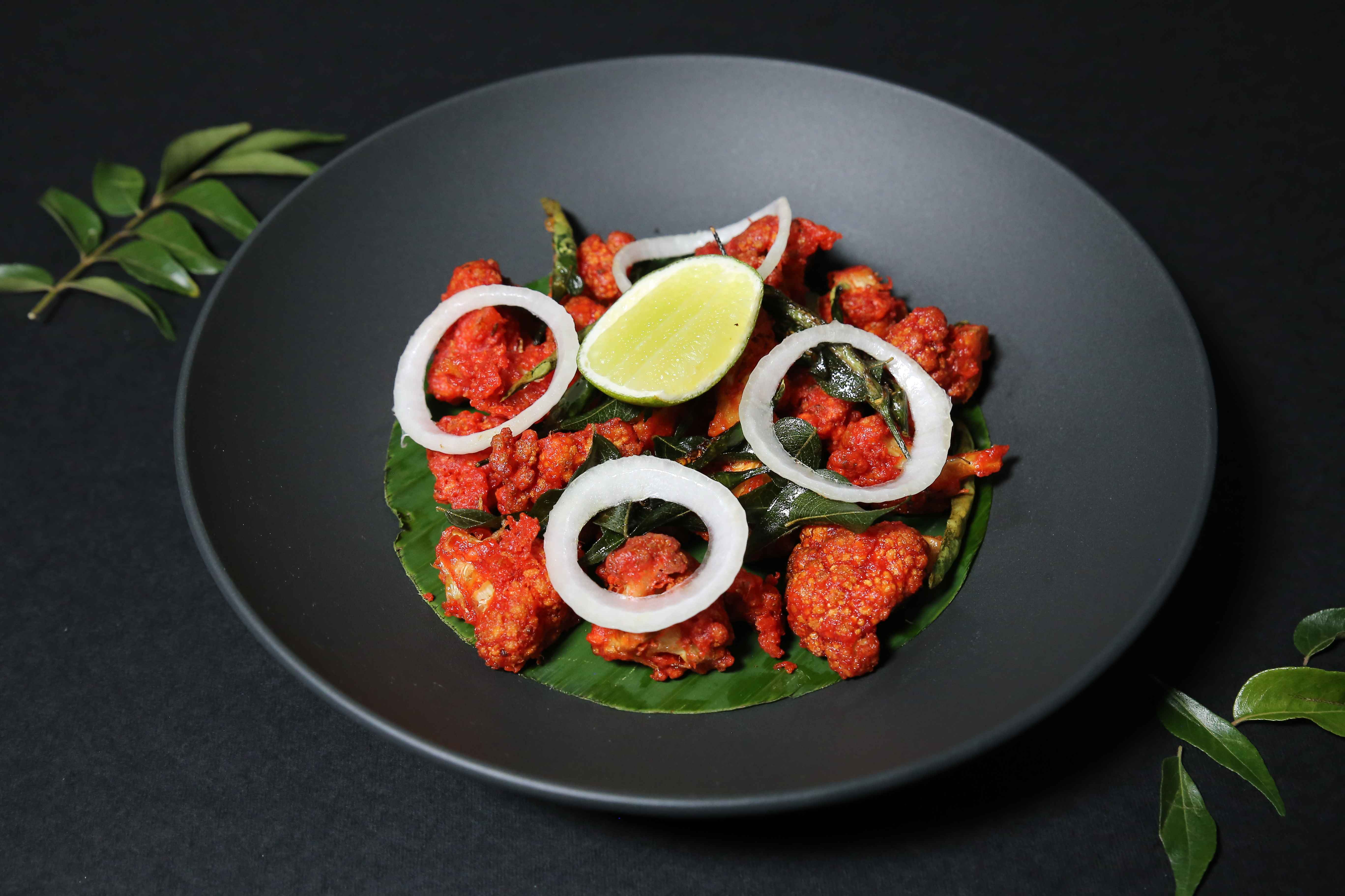 Crispy cauliflower florets tossed in a tangy Indo-Chinese sauce perfectly paired with fried rice or noodles or as a starter to share.